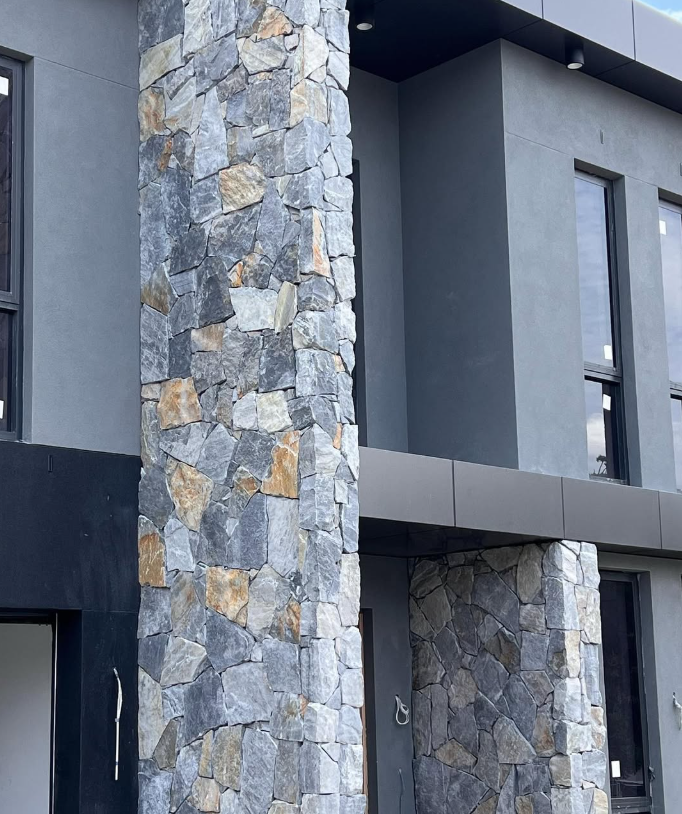 A close-up of Verona Stone Cladding reveals irregular gray and brown rocks with hand-split surfaces, showcasing varied textures and natural color, ideal for free style walling.