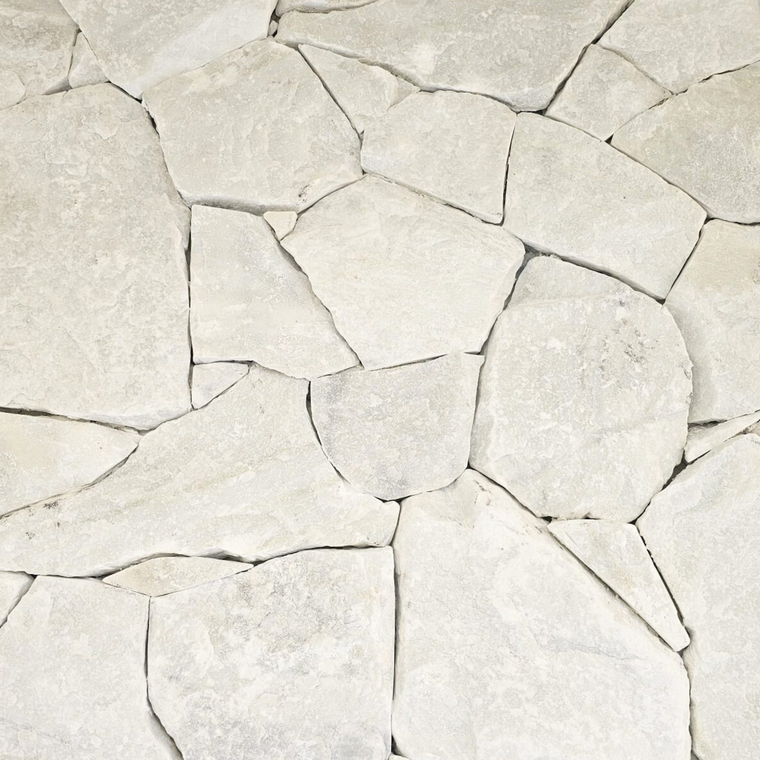 A close-up view of Mirella White Stone Cladding, featuring irregularly shaped, light-colored slabs with rough textures and uneven edges for a modern stone feature wall. — Stone Cladding