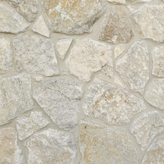 Avelon Stone Cladding features a close-up of irregular, neutral stone pieces set in mortar, creating a rough, textured surface with a free style walling pattern.