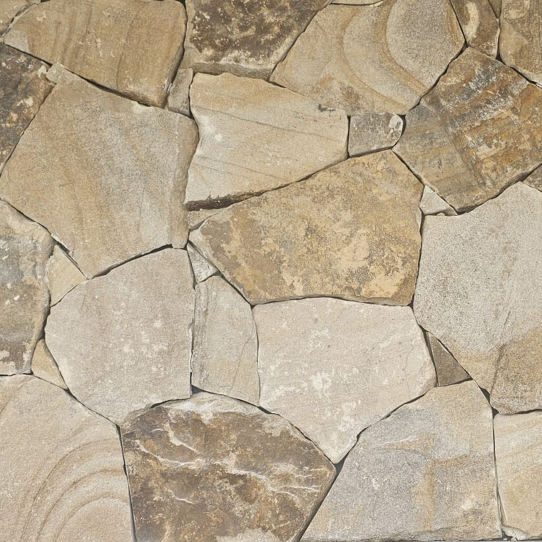 Close-up of Orana Stone Cladding, featuring irregularly shaped light brown and beige sandstone pieces with visible edges and split surface textures, arranged in a freestyle wall pattern. — Stone Cladding