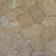 Close-up of an irregular stone wall, showcasing Stormwood Stone Cladding in tan and gray hues—ideal for feature walls or fireplaces, with visible seams and natural split textures adding distinctive character.