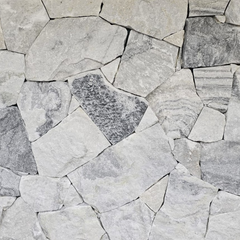 Luna Grey Stone Cladding features irregular, light gray and white quartz tiles with darker streaks, fitted in a freestyle pattern for a textured, organic stone wall look.